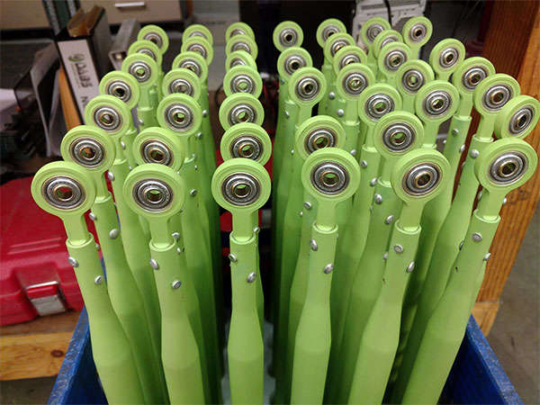 A bunch of green rollers in a blue container.